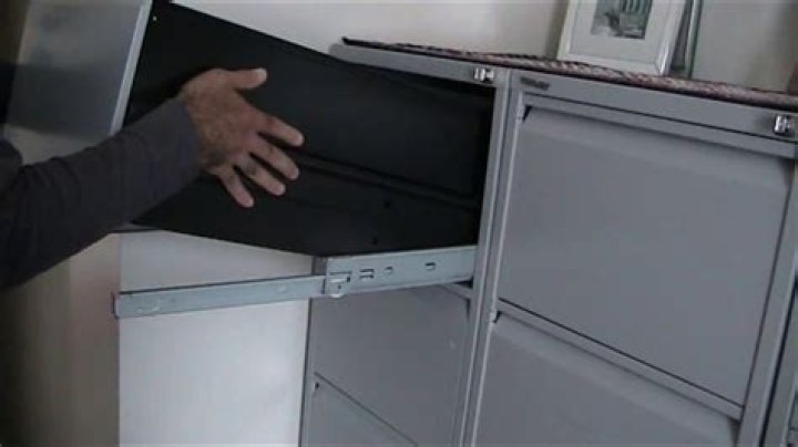 How do you take a drawer out of a filing cabinet?